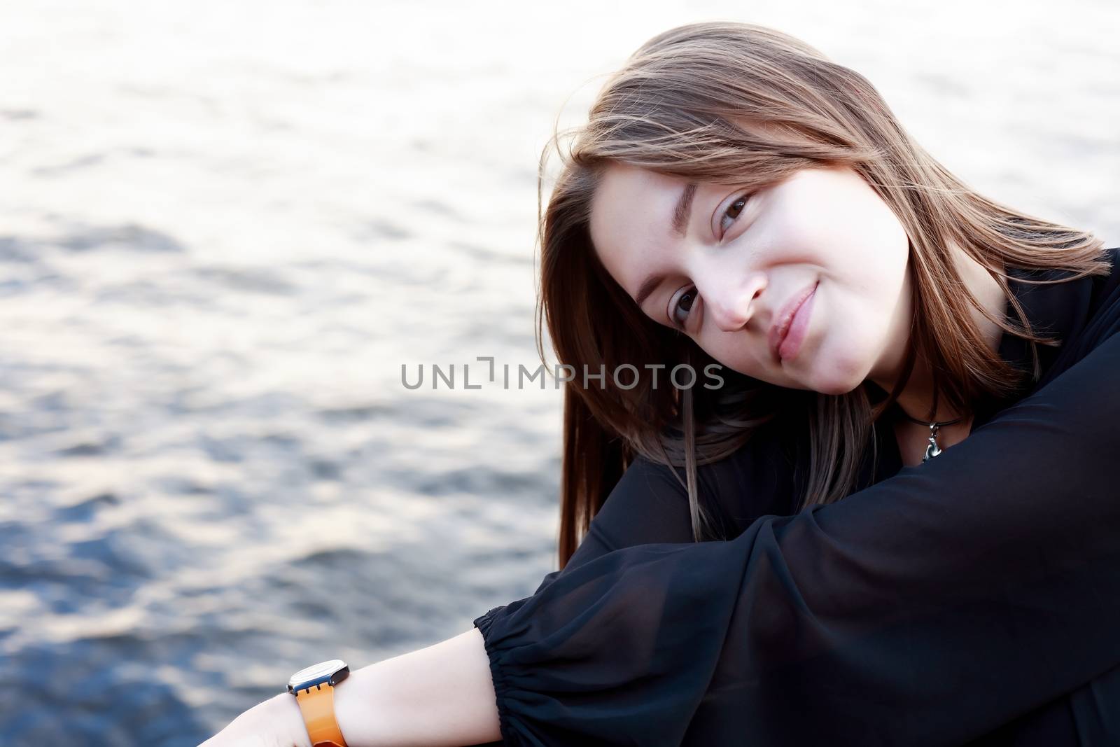 Beautiful young woman portrait against water background