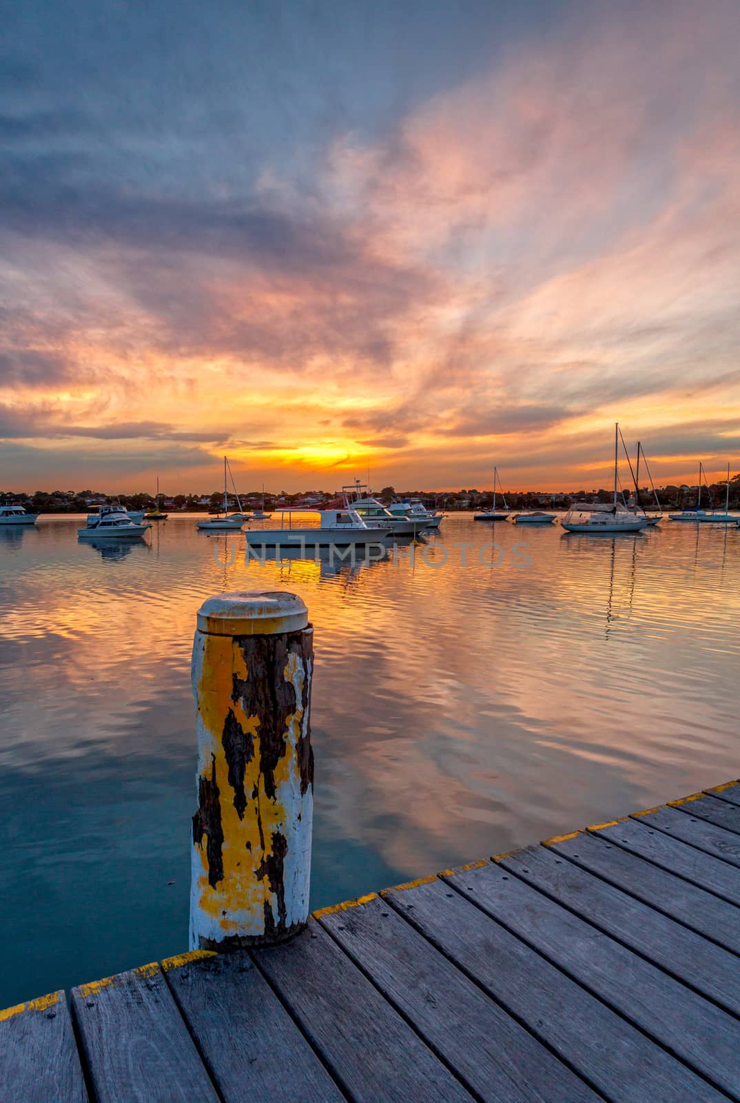 Beautiful sunset across the bay with moored yachts and boats by lovleah
