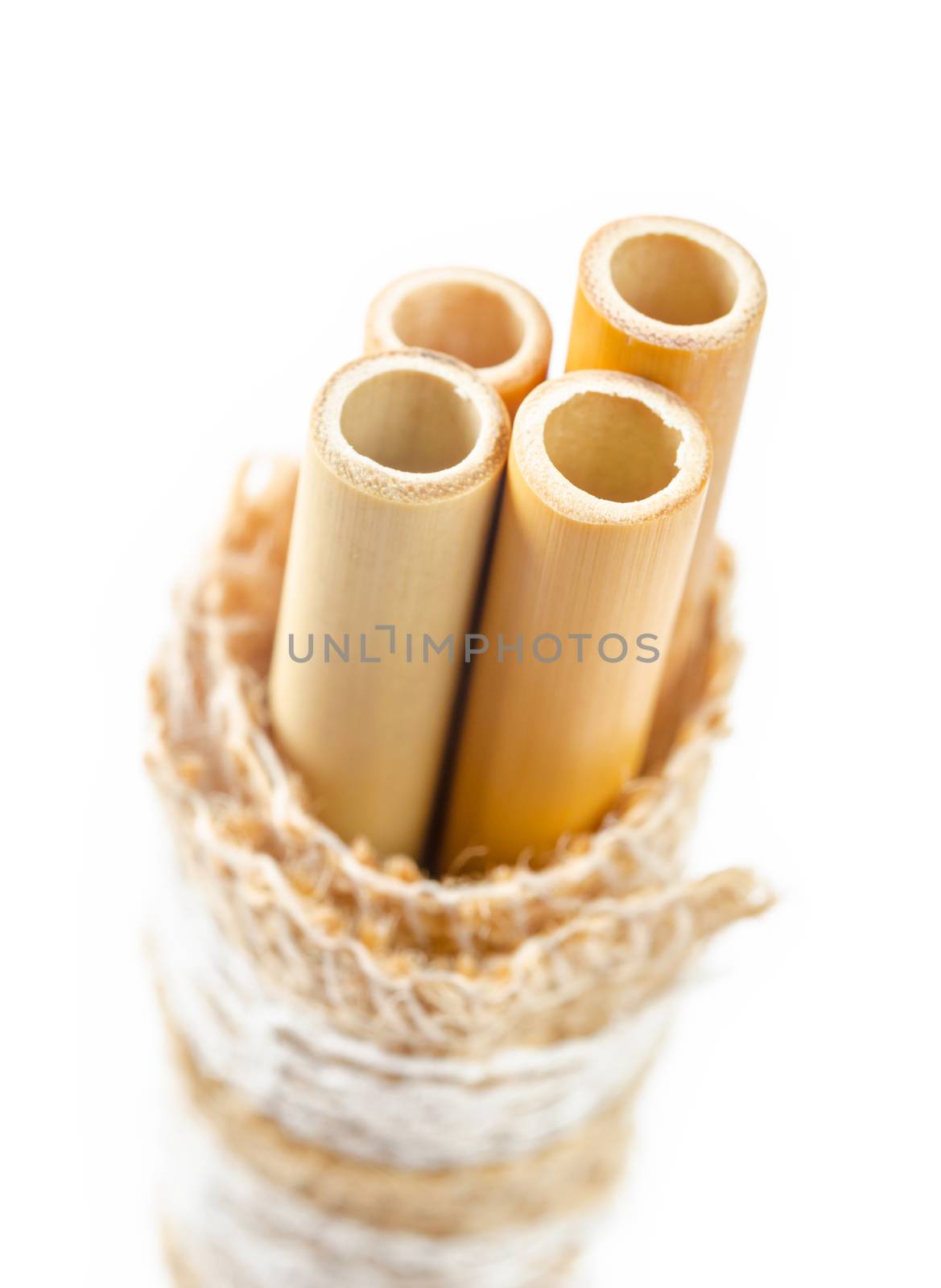 Ecological bamboo straws tube for drinking water on white background.