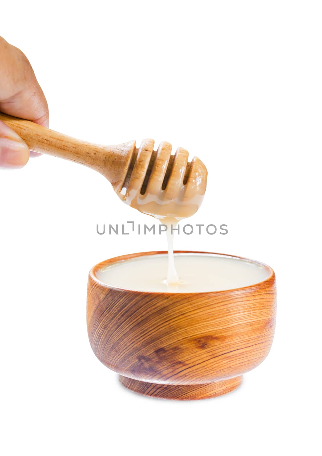 pouring condensed milk into wooden bowl. by Gamjai