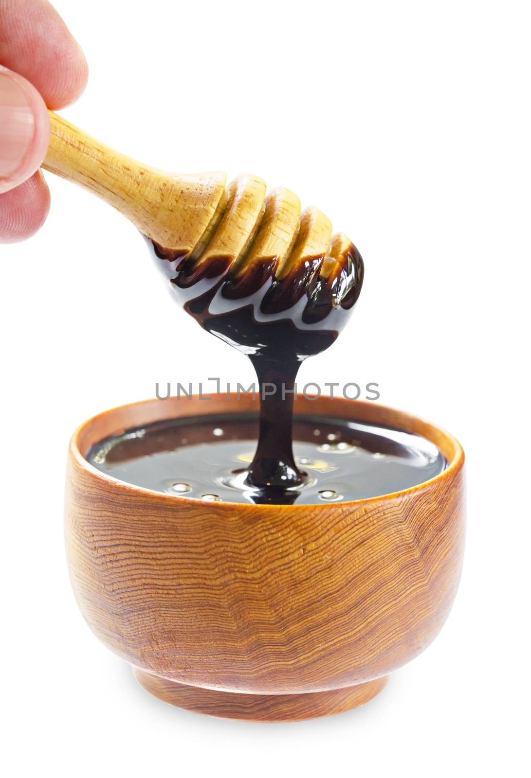 close up pouring chocolate melt into wooden bowl isolated on white background, Save clipping path.