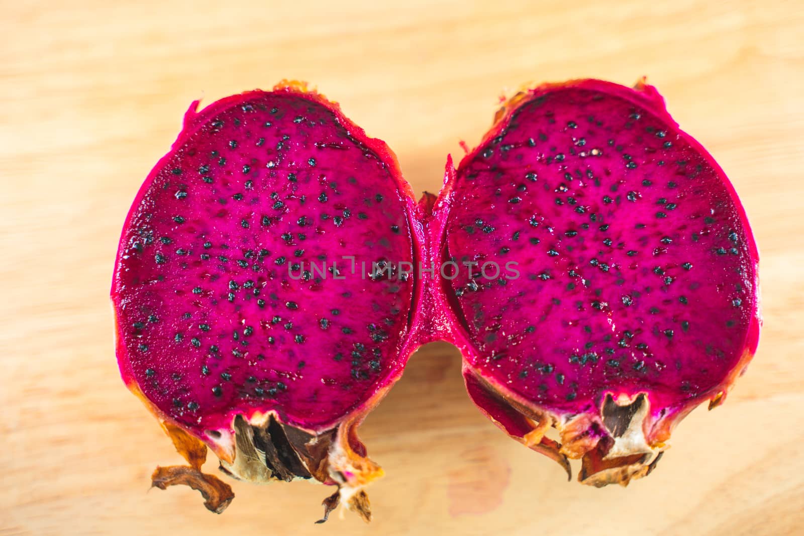 The Dragon fruit (Pitaya) with half on wooden background clipping part.