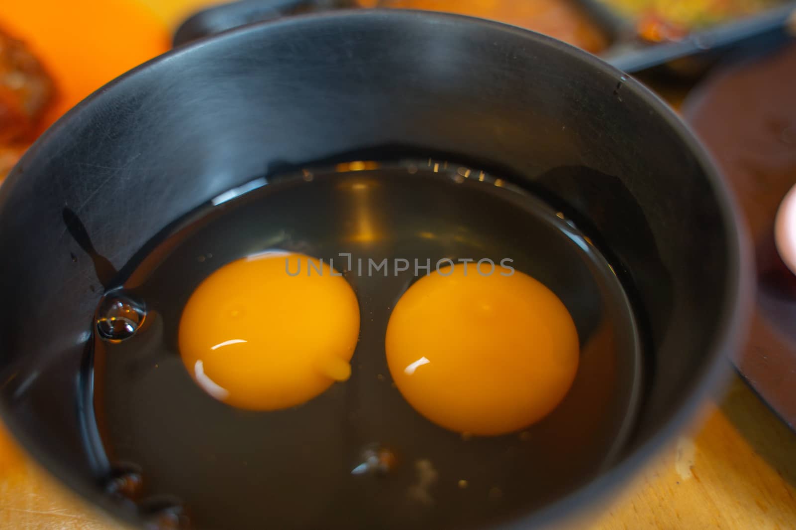 A Yellow egg white and yolk baking ingredient in a black bowl