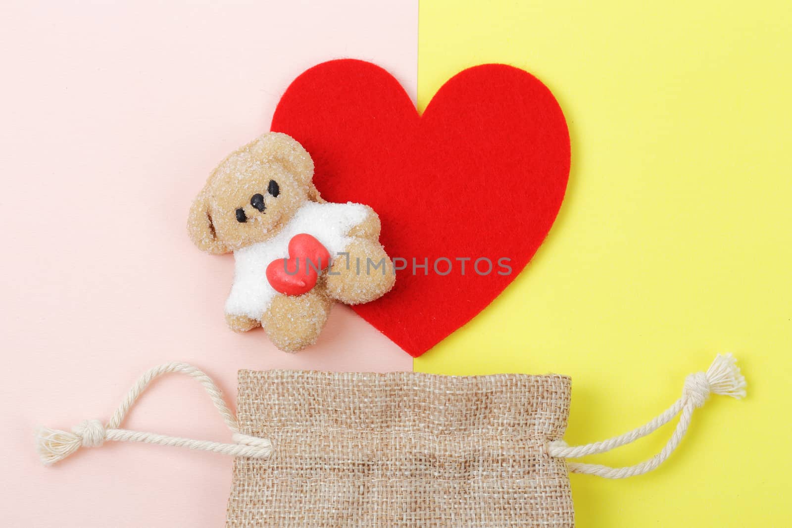 Sweet of marshmallow bear with red heart over colorful paper background, Valentine's day concept.
