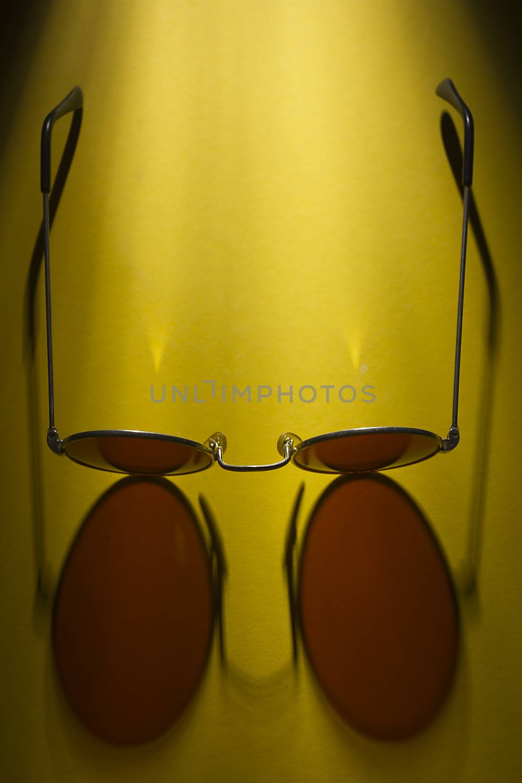 Round sunglasses on a yellow surface by VIPDesignUSA