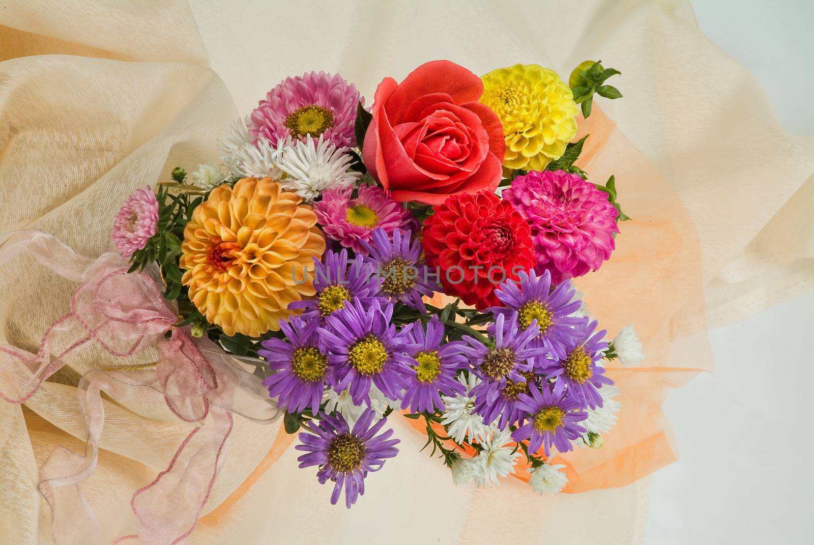 Still life with bouquet of flowers and accessories on a studio background