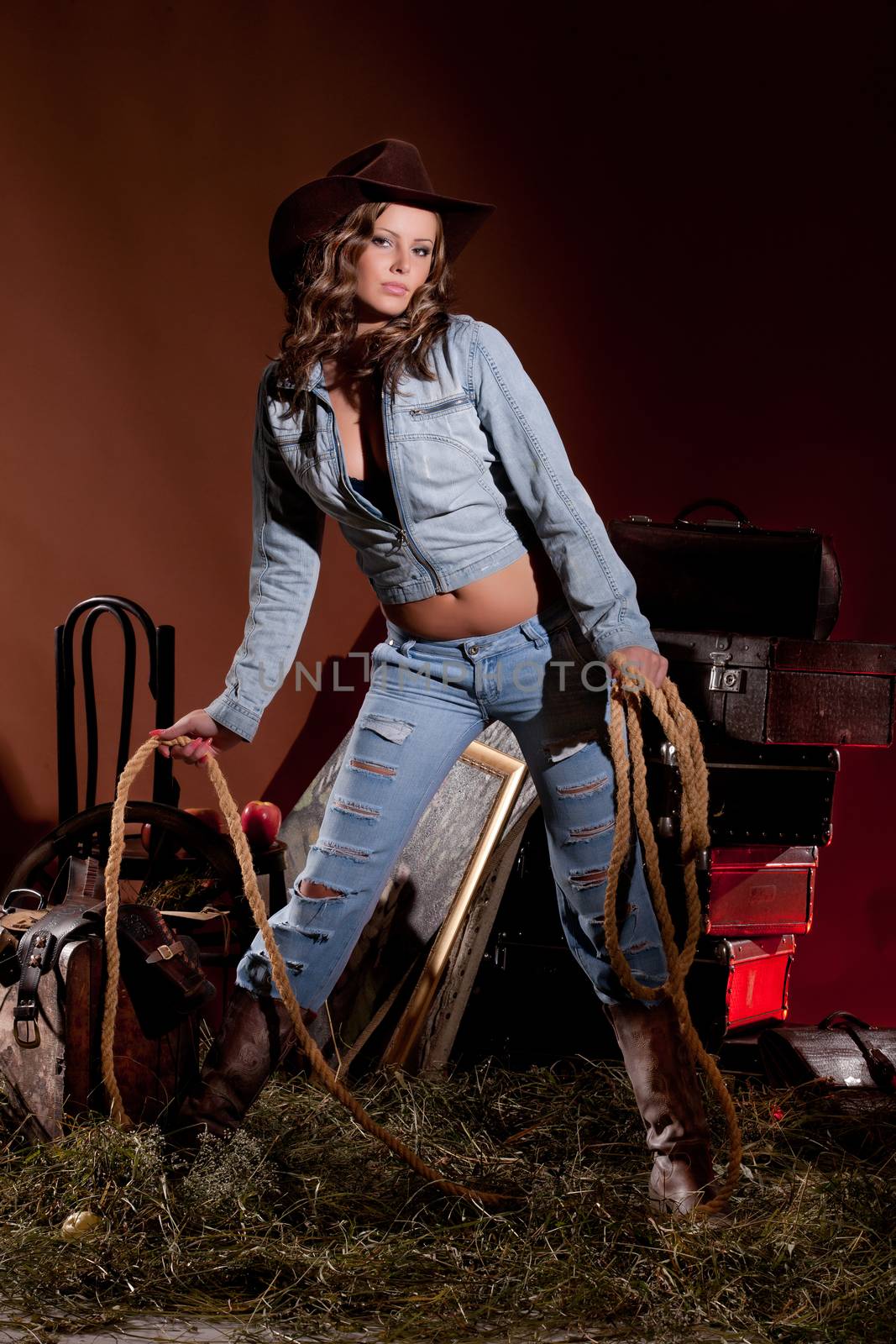 Young beautiful woman dressed in western style with lasso
