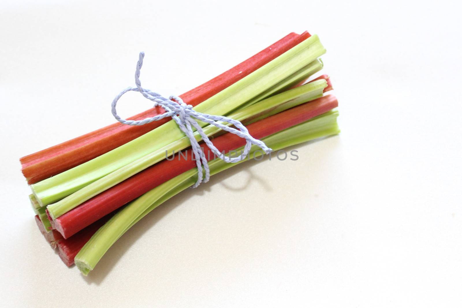 The picture shows colorful delicious rhubarb on a white background.