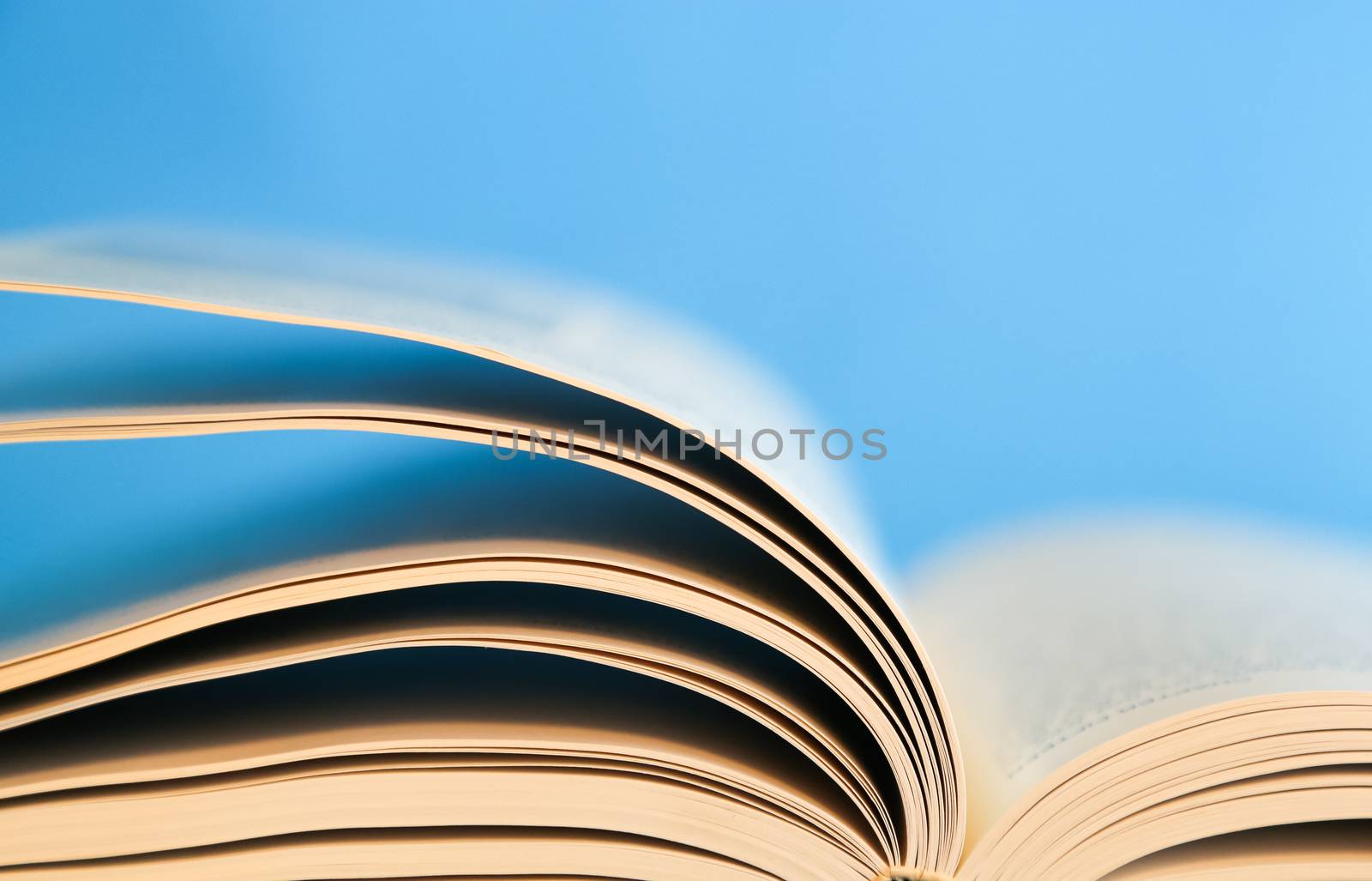 Blue background with pages of a book turning