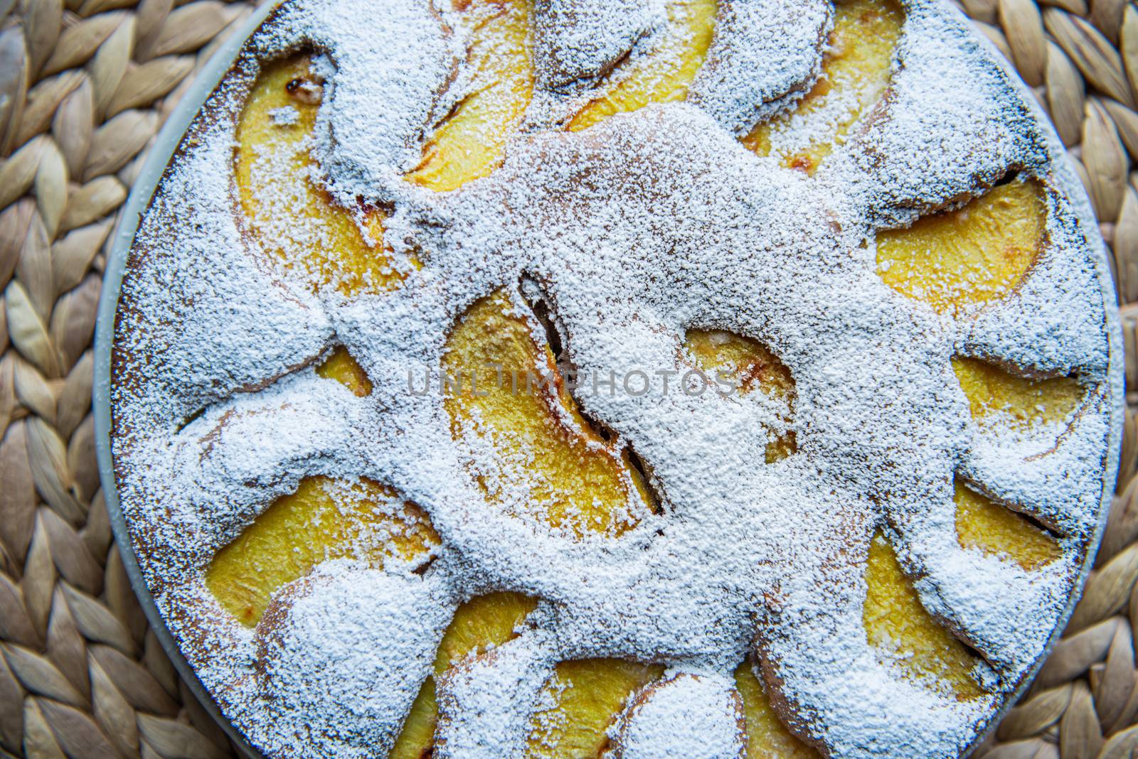 Russian charlotte decorated with peach slices and and icing sugar with empty space for text