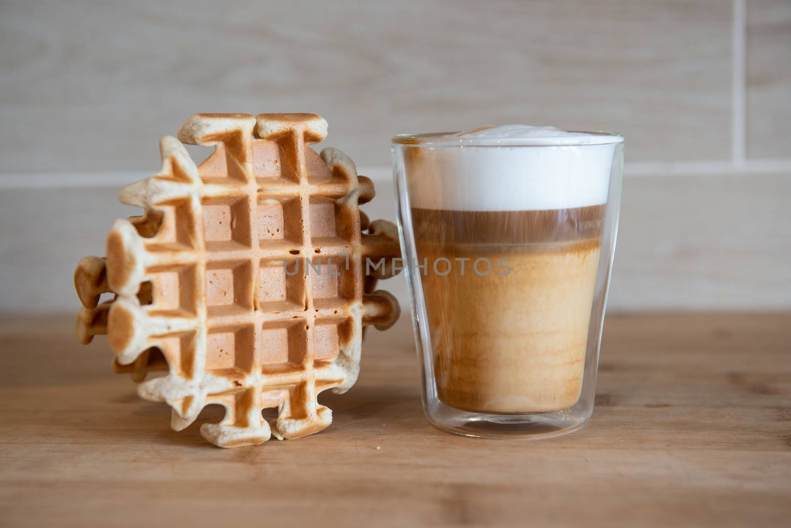 Glass cup of multilayer coffee with mini stroopwafel, syrupwaffles by marynkin