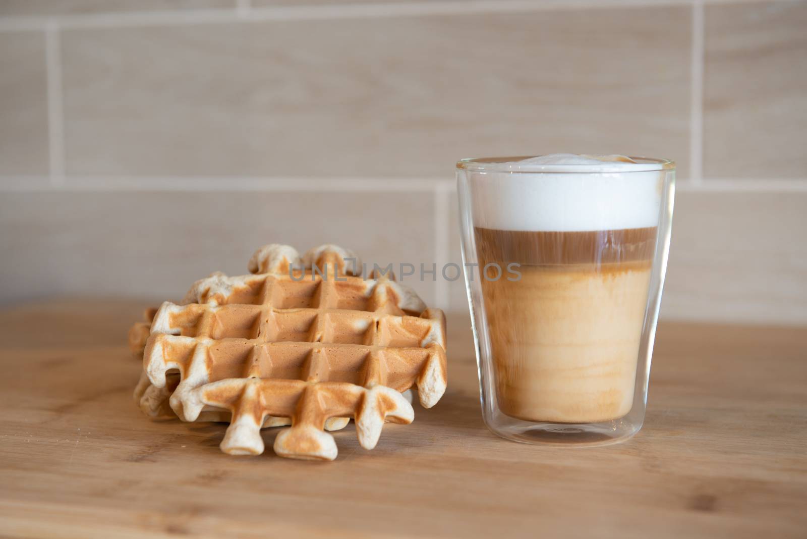 Glass cup of multilayer coffee with mini stroopwafel, syrupwaffles by marynkin