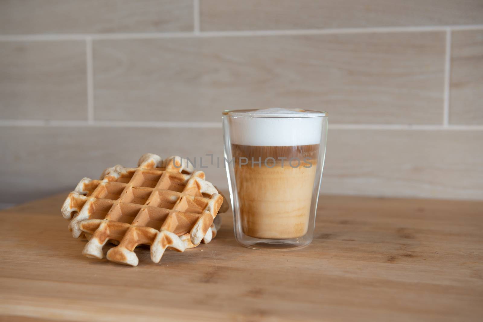 Glass cups of multilayer coffee with mini stroopwafel, syrupwaffles cookies on light gray background with copy space. waffle cookies