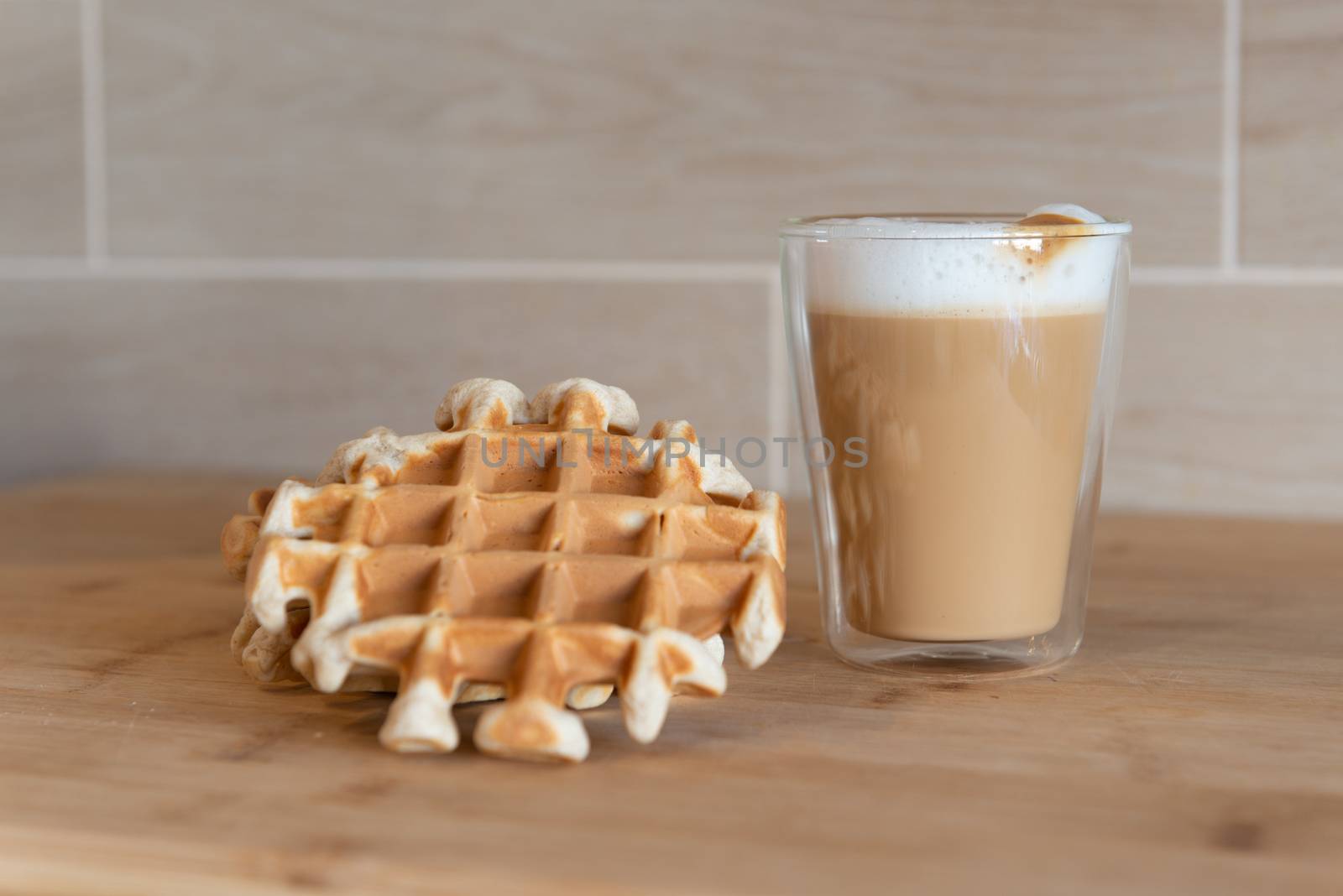 Glass cups of multilayer coffee with mini stroopwafel, syrupwaffles cookies on light gray background with copy space. waffle cookies