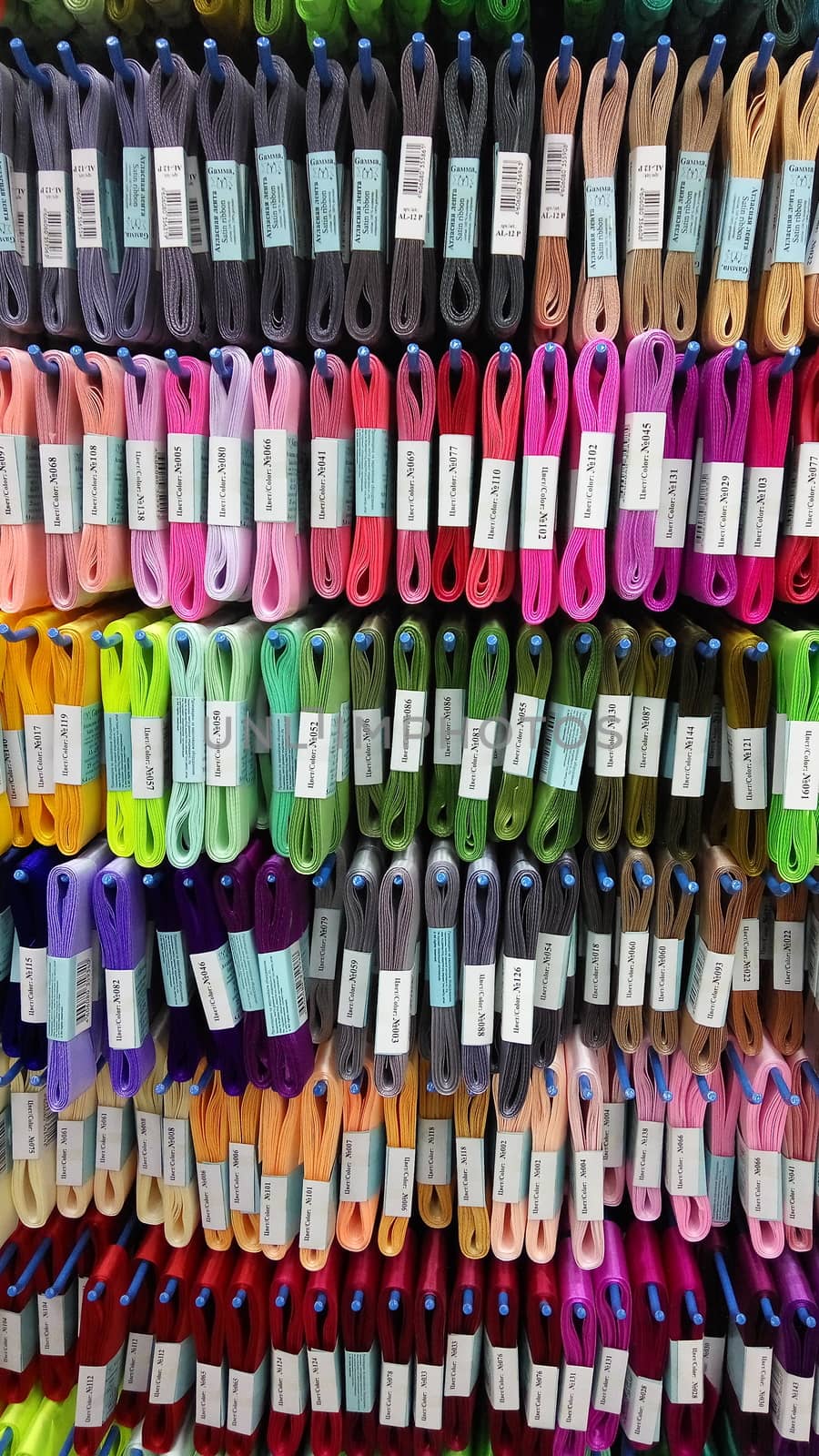 Set of colored threads for sewing on coils. Pile of big colorful spools of thread. by marynkin