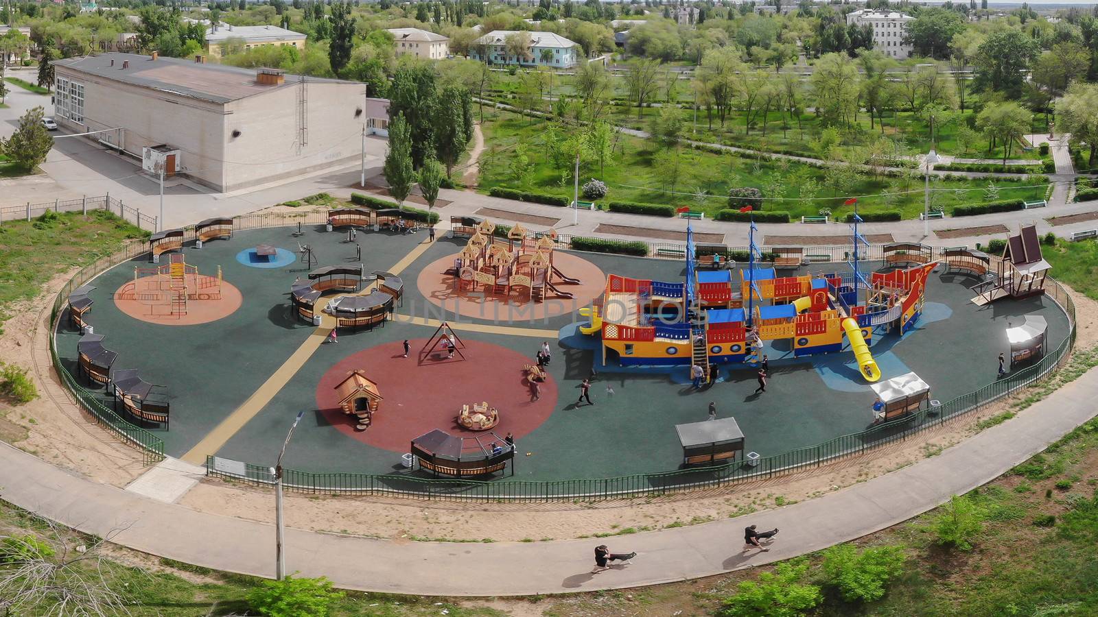 Children playground on yard activities in public park. Russia 2019. Children run, slide, swing, seesaw on modern playground. Urban neighborhood childhood concept.