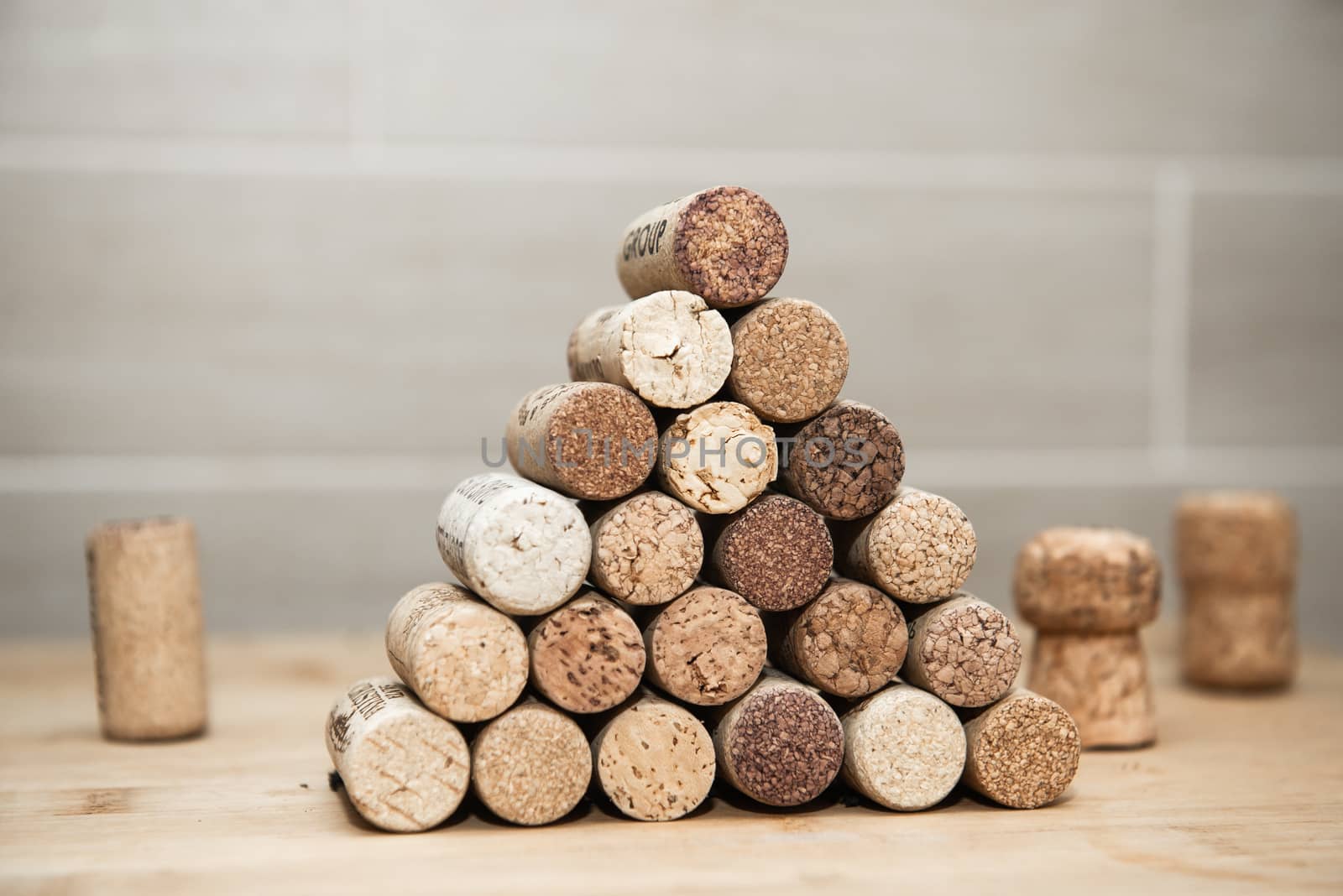 Heap of assorted wine corks on brick and wooden background.