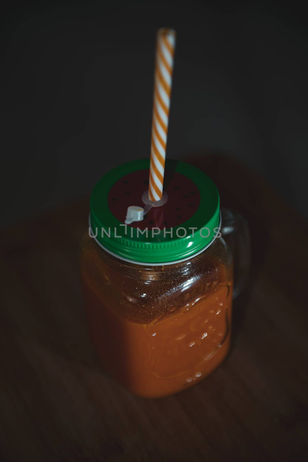 Fresh juicy in mason jar with a color straw by marynkin