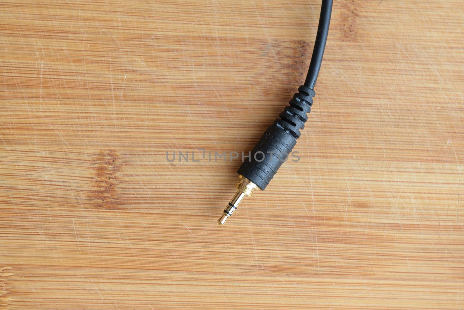 golden stereo jack plug on wooden ground by marynkin