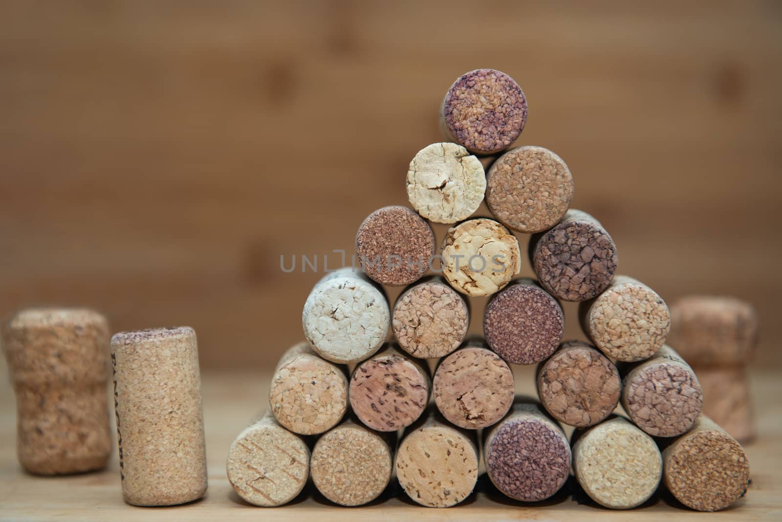 Heap of assorted wine corks on brick and wooden background.