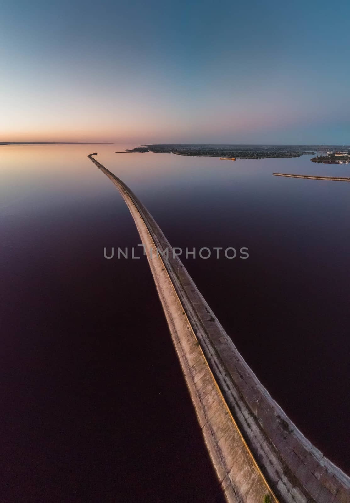 Aerial view of the curve of the road through the reservoir by marynkin