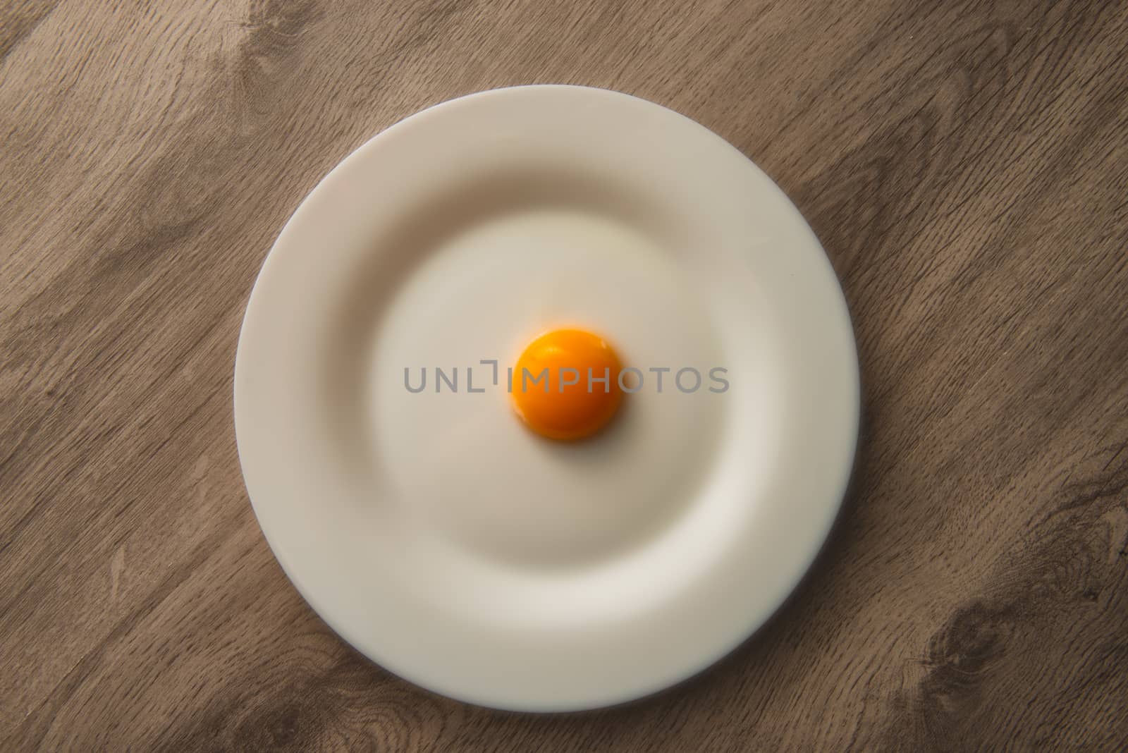 egg yolk on white plate by marynkin