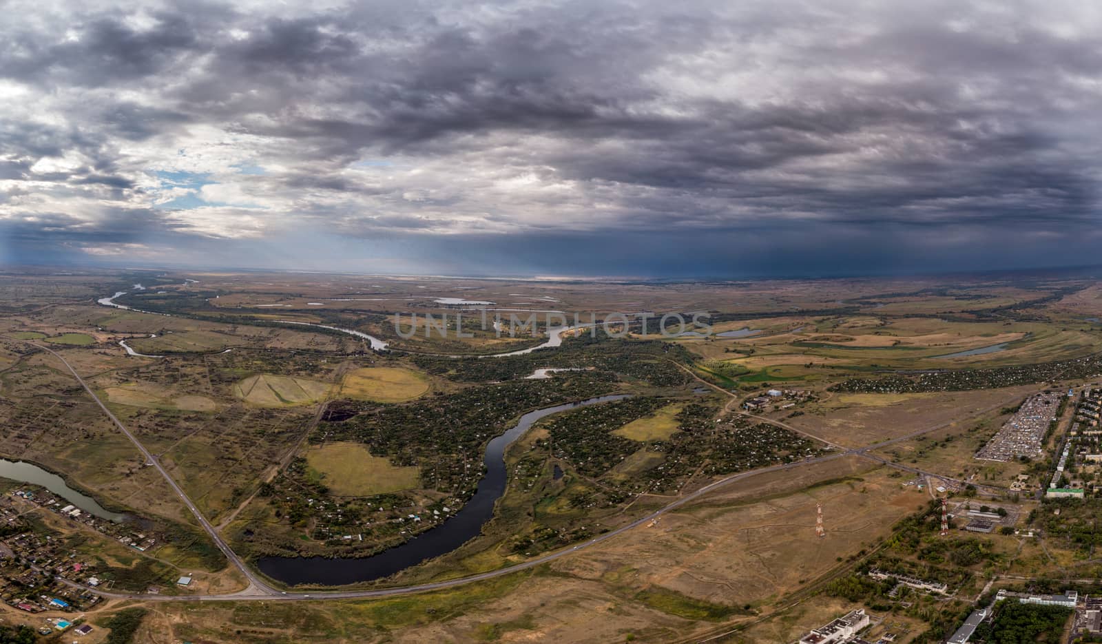 Aerial view on flowing river and town. Akhtuba River and Volga River