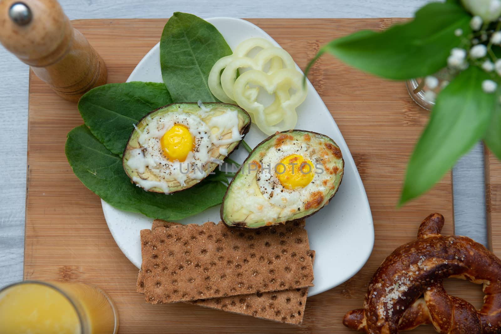 Eggs baked in avocado on plate by marynkin