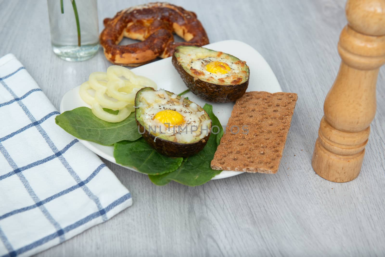 Eggs baked in avocado on plate by marynkin