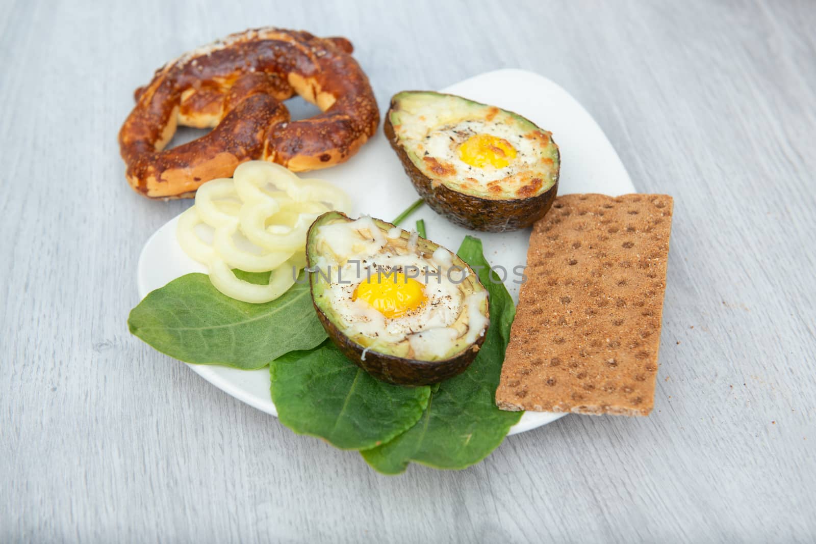 Eggs baked in avocado on plate by marynkin