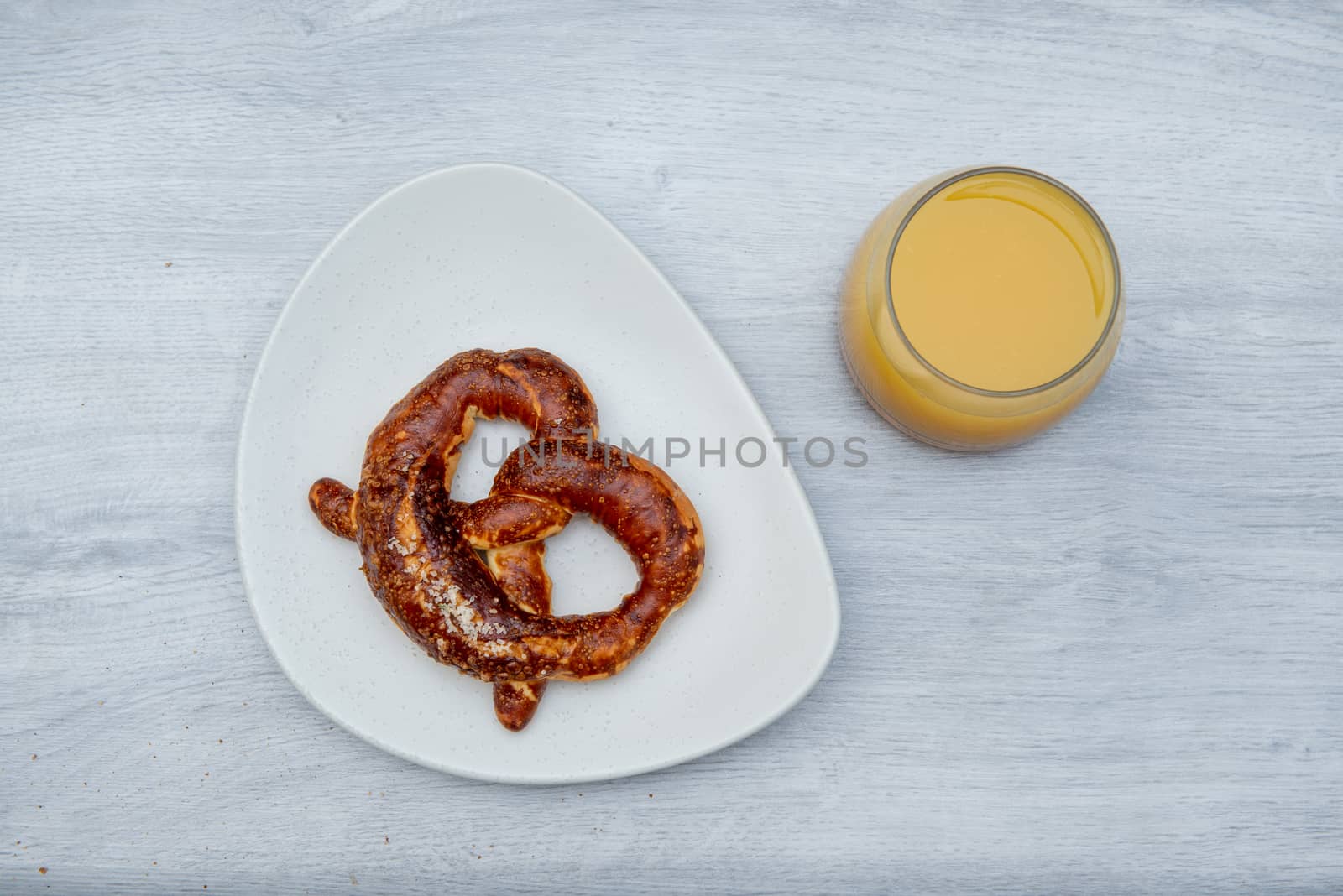 Eggs baked in avocado on plate with pretzel and juicy by marynkin