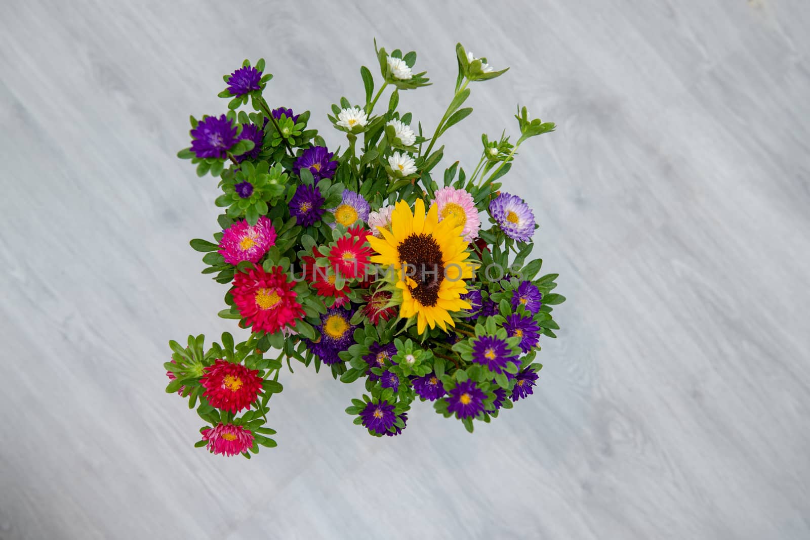 Garden flowers over grey wooden table background. Backdrop with copy space.