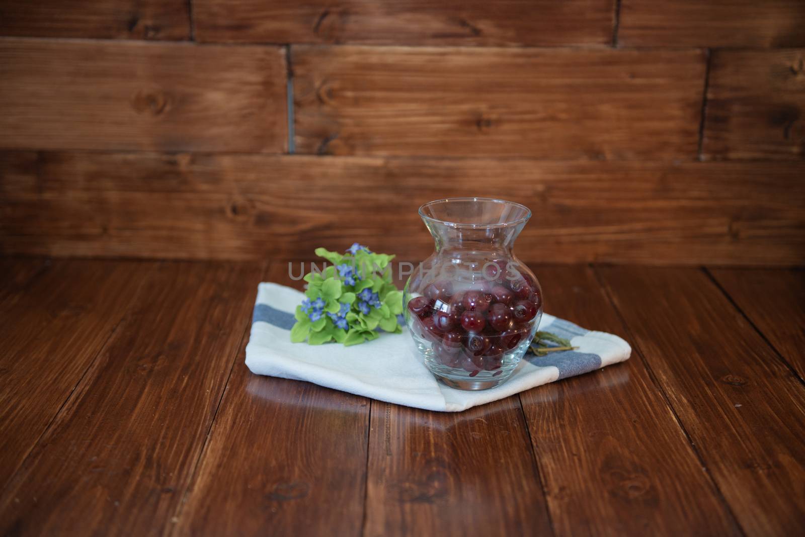 cherry in a vase on wooden background with towel