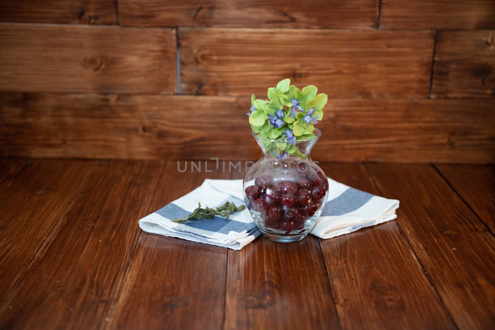 cherry in a vase on wooden background with towel