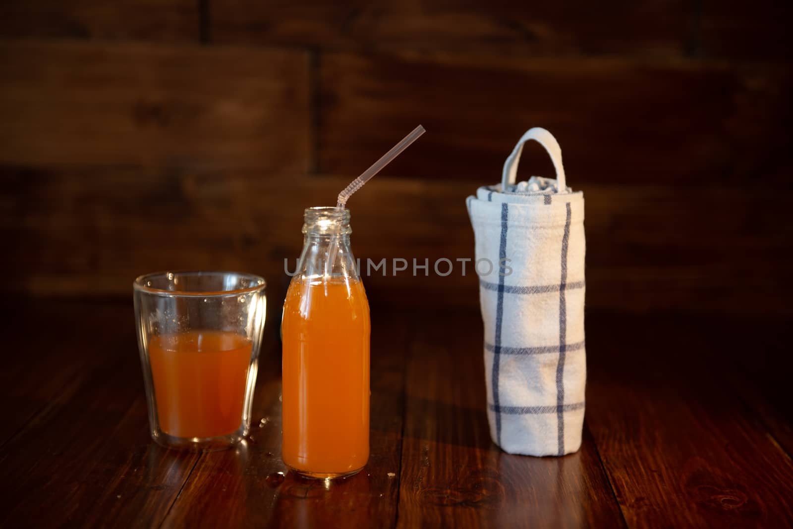 vintage bottle with juice, straw and towel on wooden table by marynkin