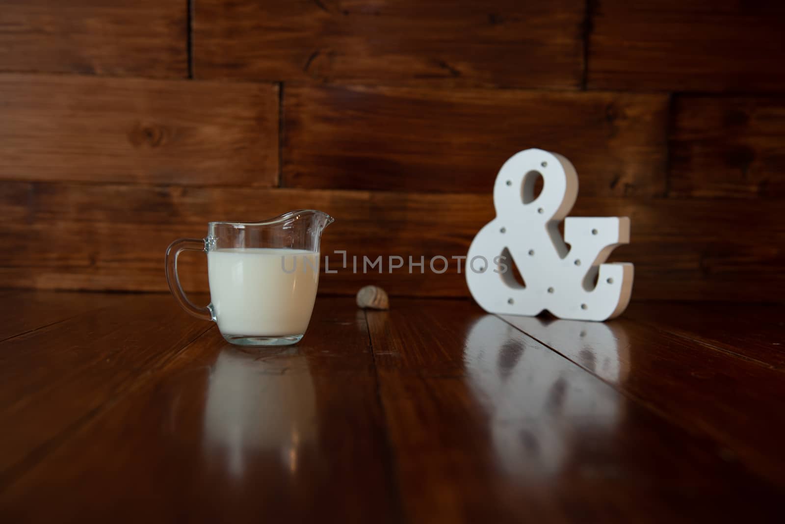 milk in glass milk jug and a glowing ampersand by marynkin