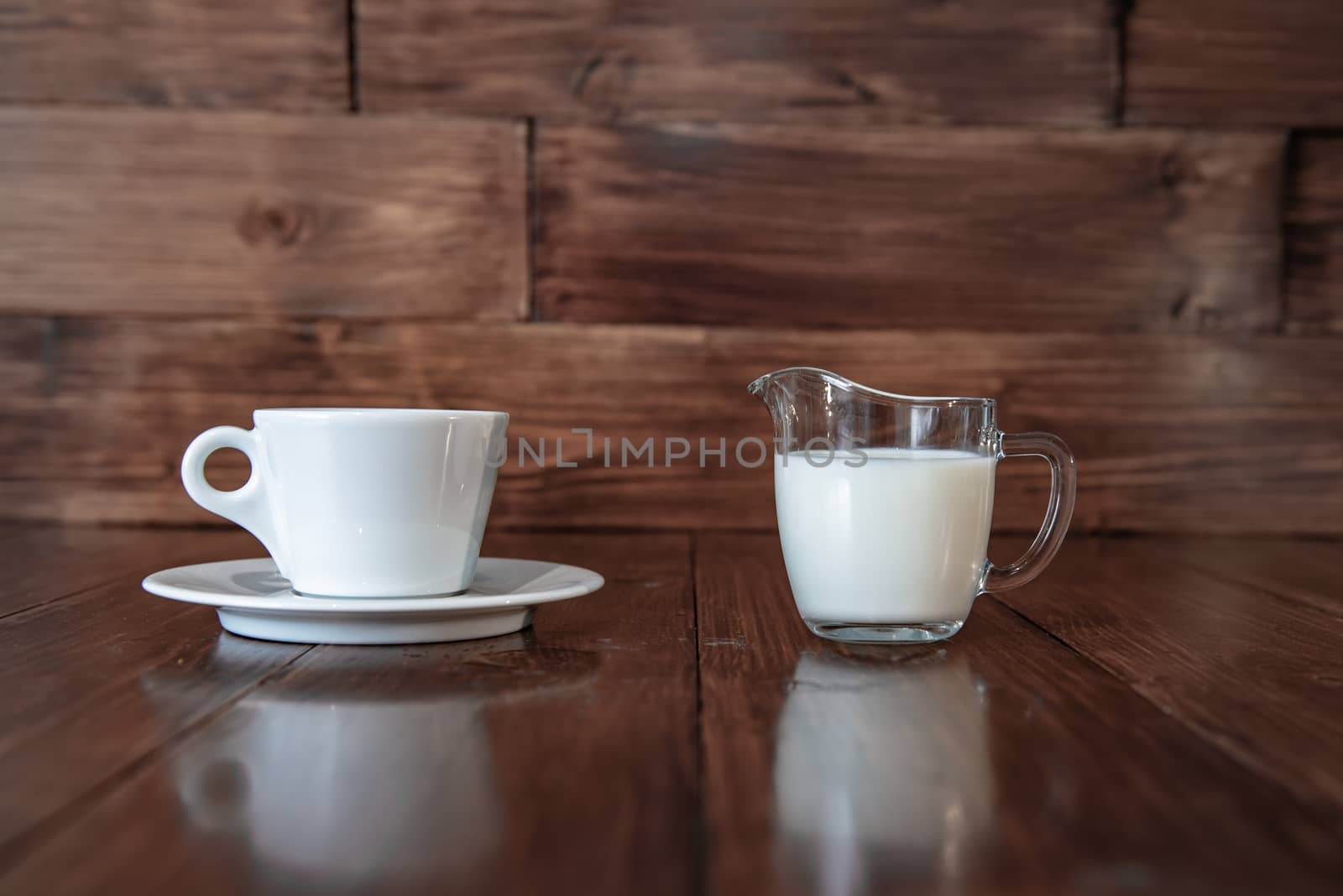 milk in glass milk jug with white cup by marynkin