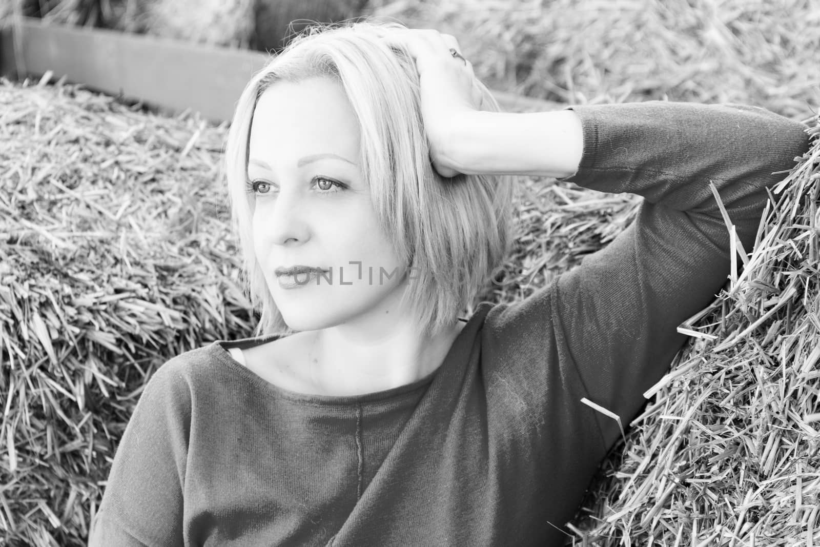 young woman or girl lying on a bale of hay. a photo. portrait