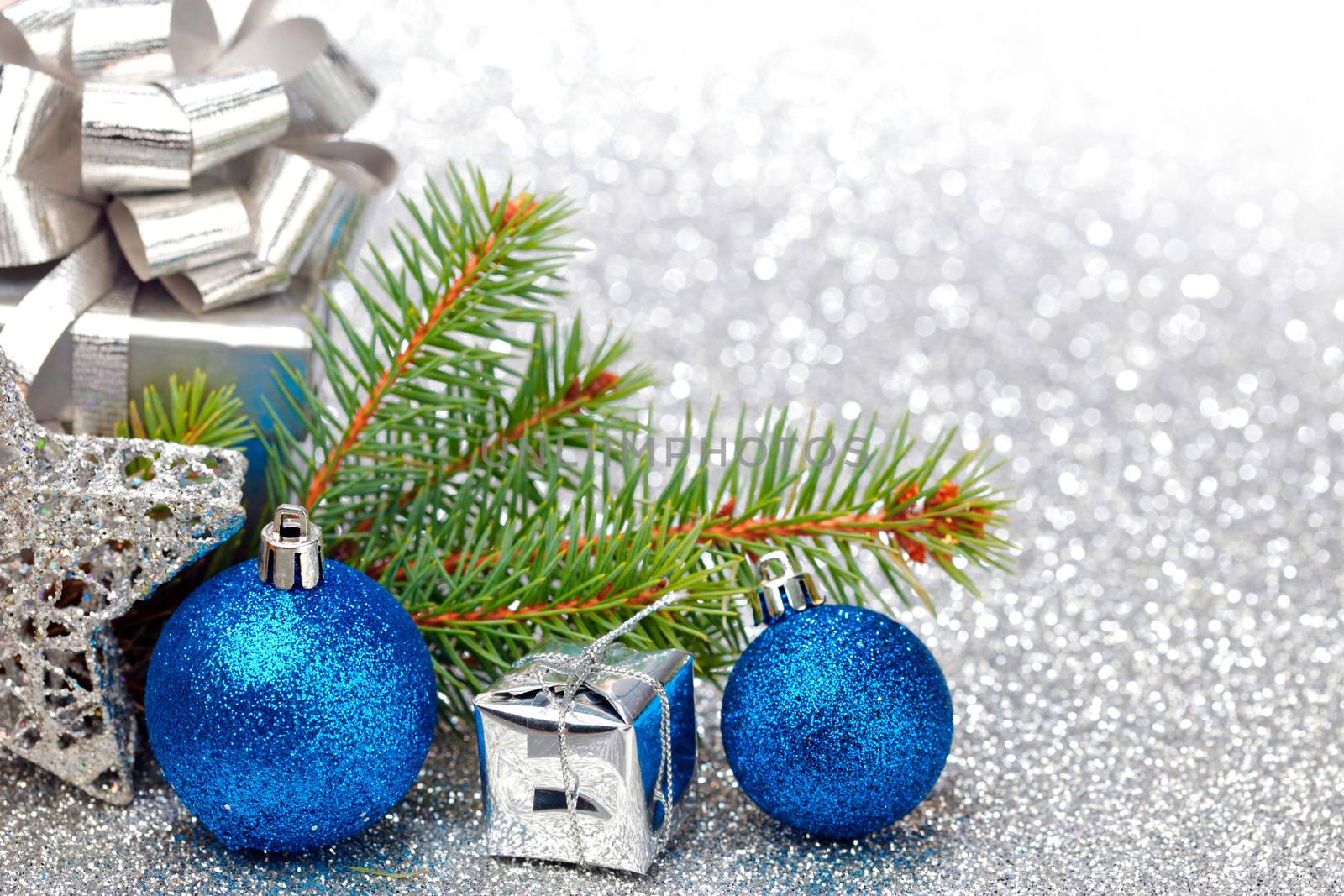 Christmas fir tree branch and decoration on silver glitter background