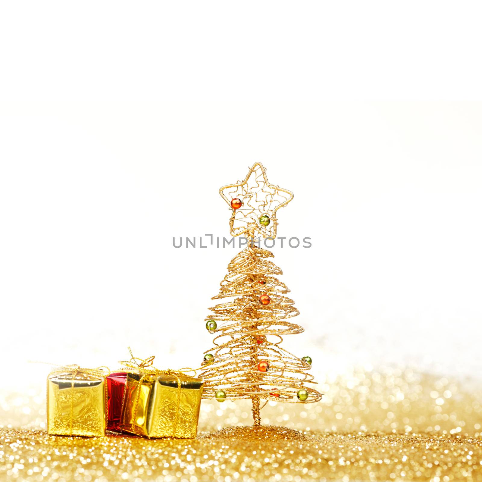 Decorative golden toy christmas tree and gifts isolated on white