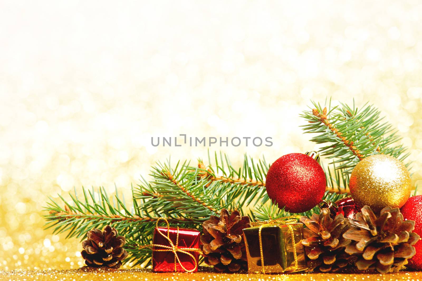 Christmas card with fir tree branch and decoration on golden glitter background