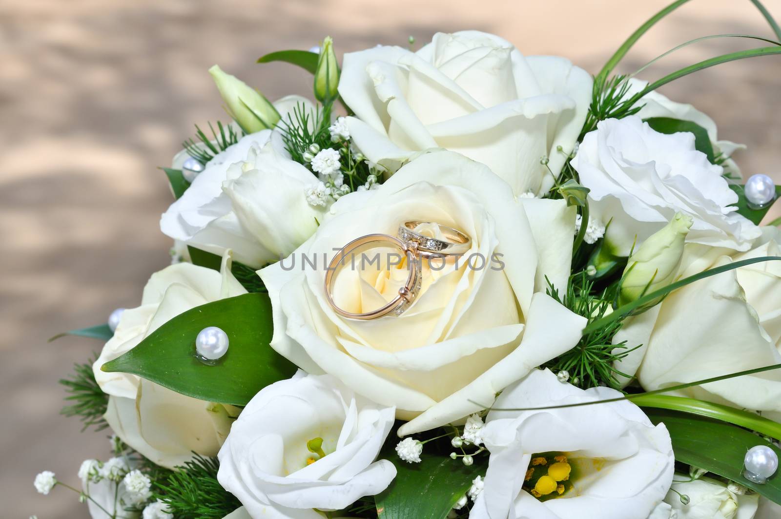 Wedding rings on a bouquet of white flowers by marynkin