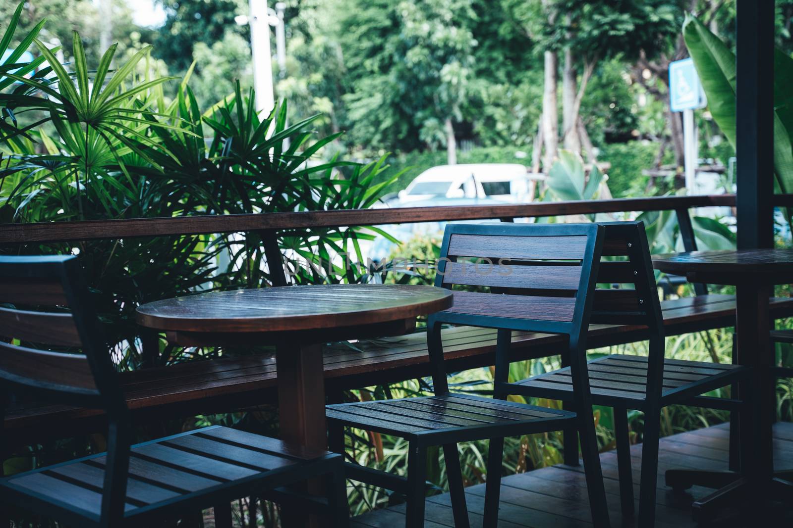 Table and chairs in a tropical garden by peerapixs