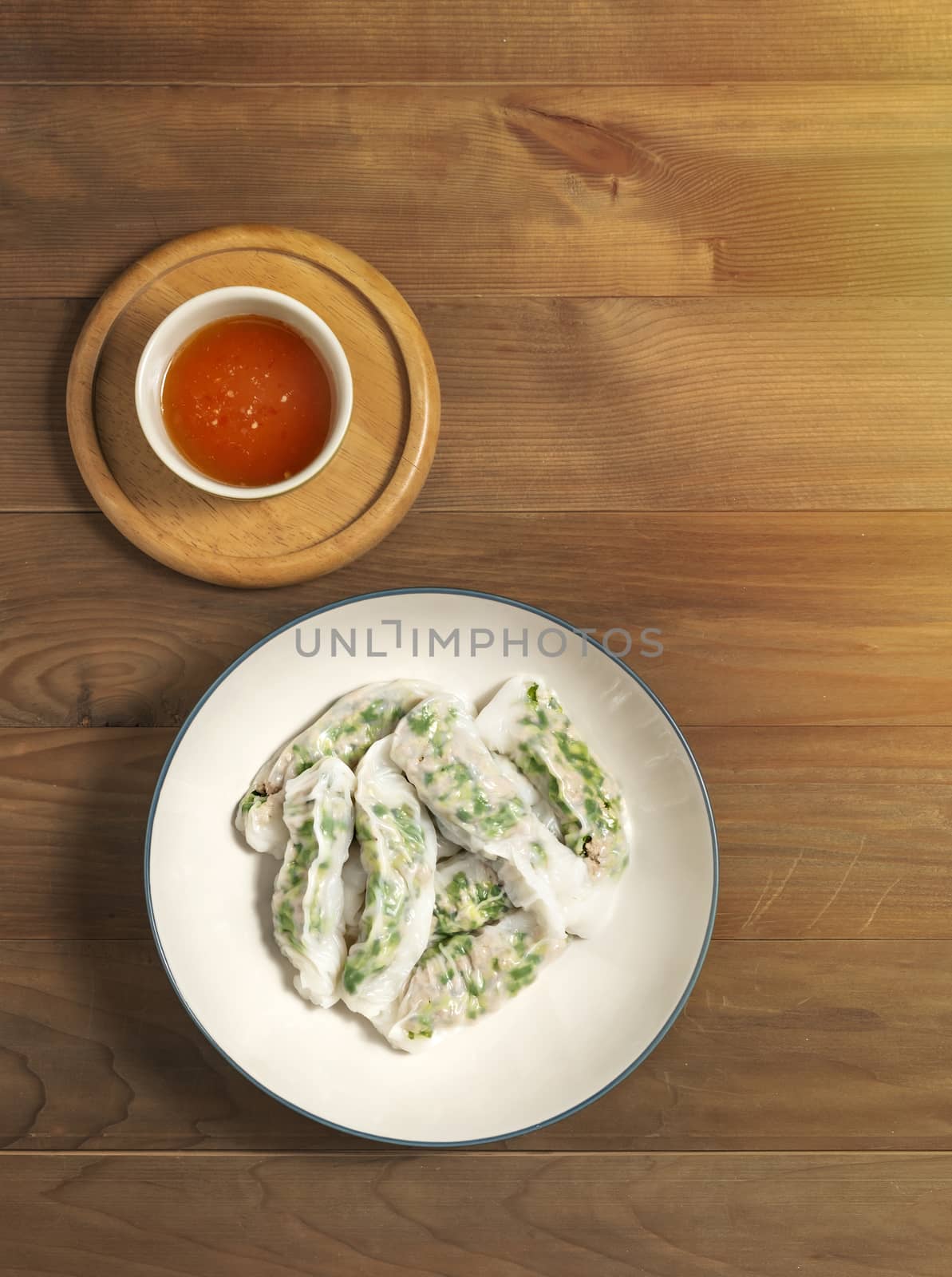 Top view Vietnamese Steamed Rice Dumplings served with spicy chili sauce over wooden table