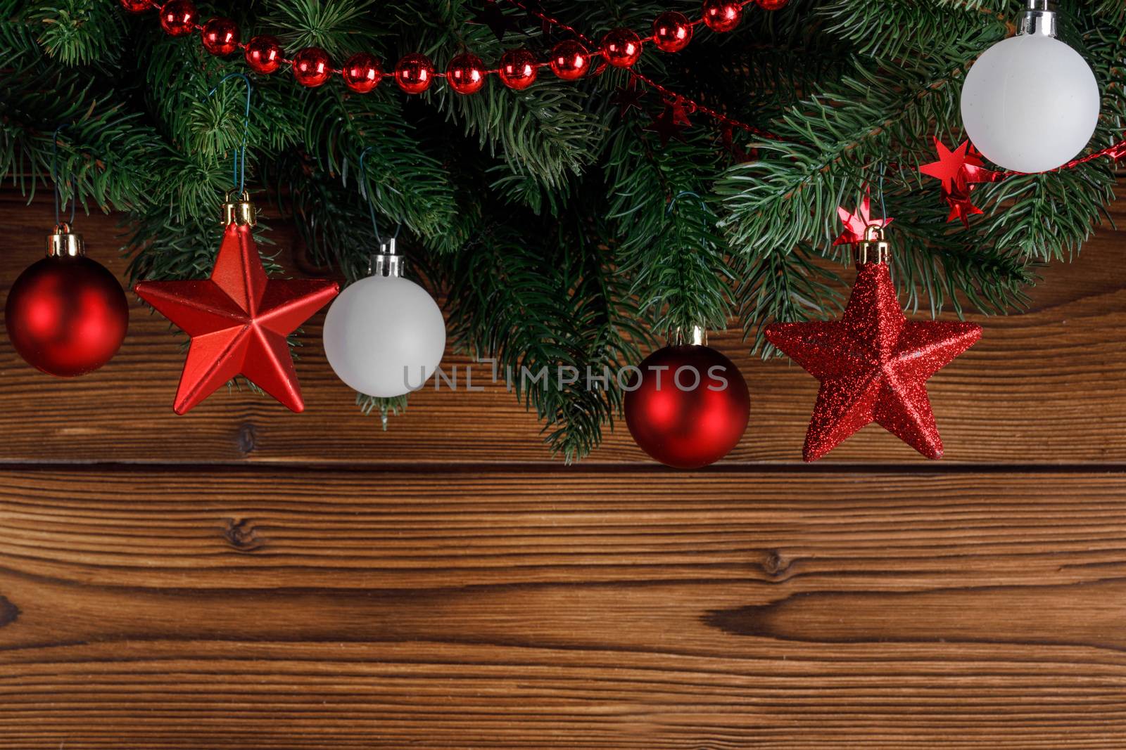 Christmas decoration frame on wooden background, fir tree branch, red and white baubles