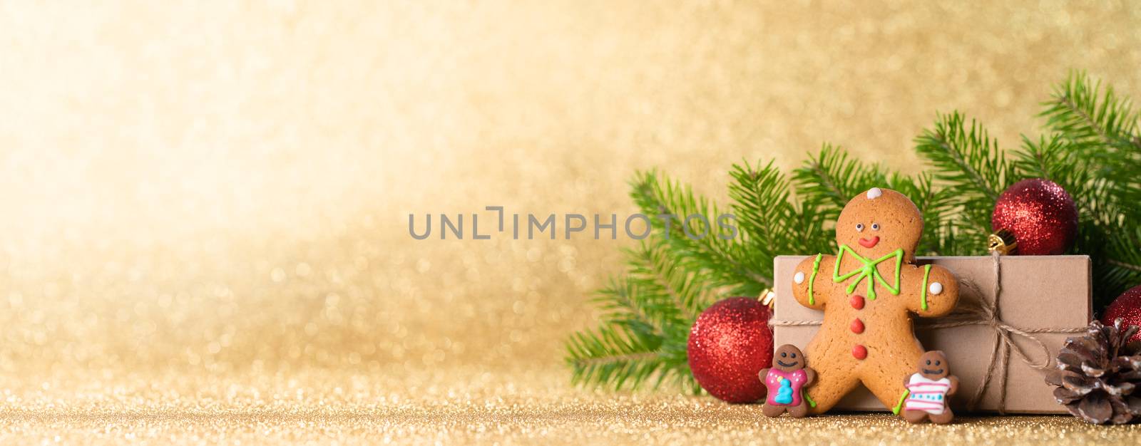 Christmas toys, decorations, present gift box wrapped in kraft paper on golden glitter background, copy space