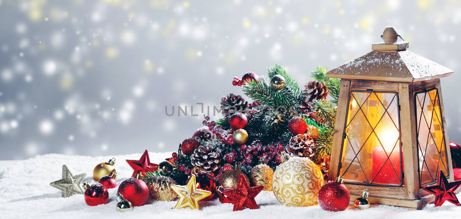 Burning candles , lantern and christmas decoration on snowfall background