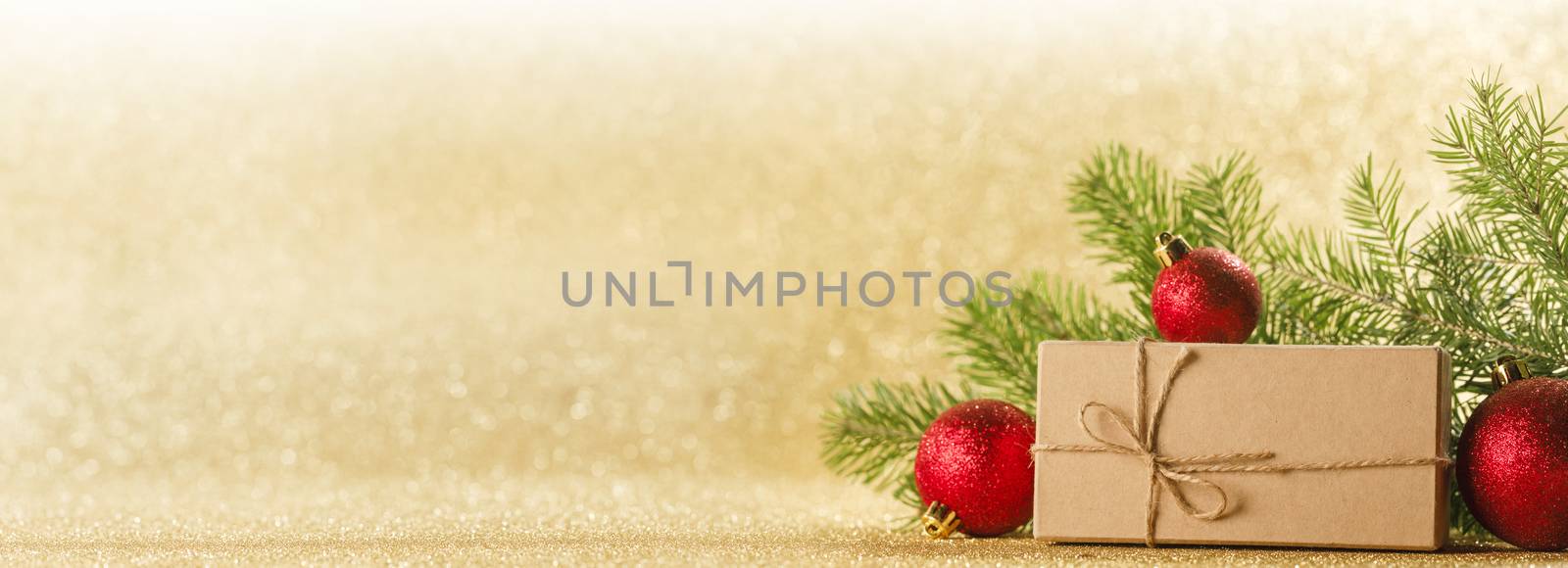 Christmas toys, decorations, present gift box wrapped in kraft paper on golden glitter background, copy space