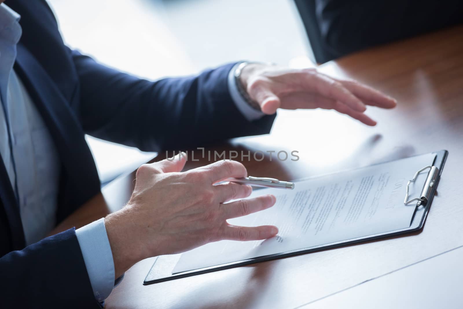 Close-up of businessman keeping hands on contract