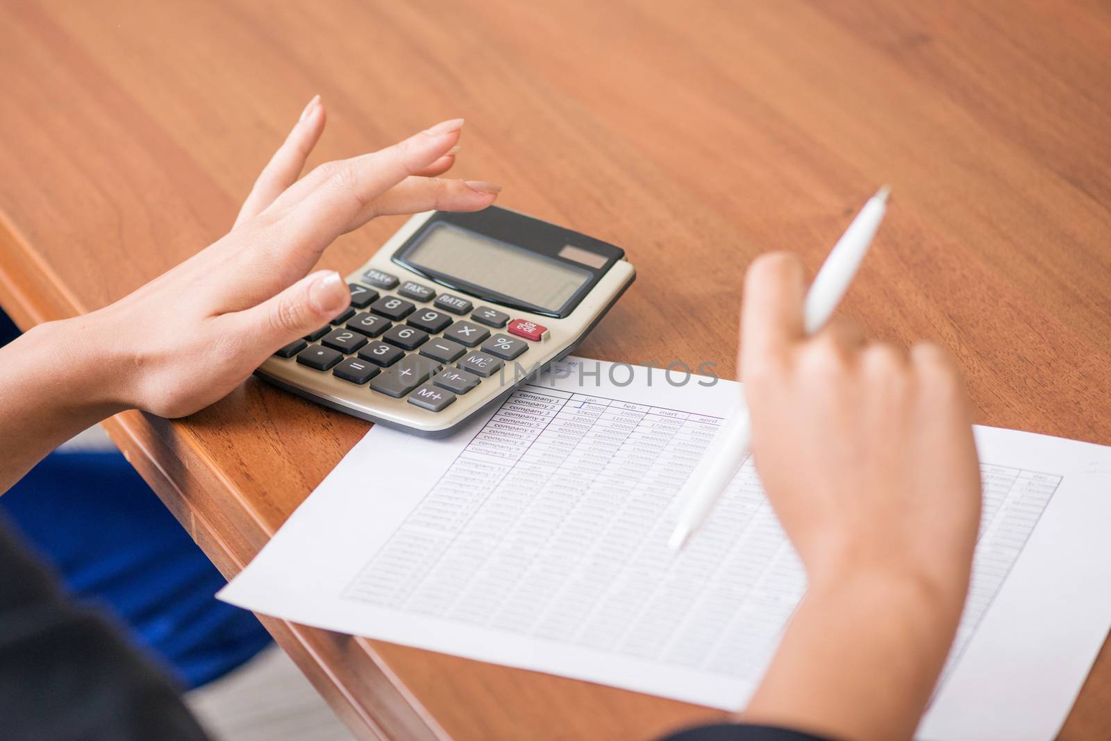 Business woman with calculator and diagrams by ALotOfPeople